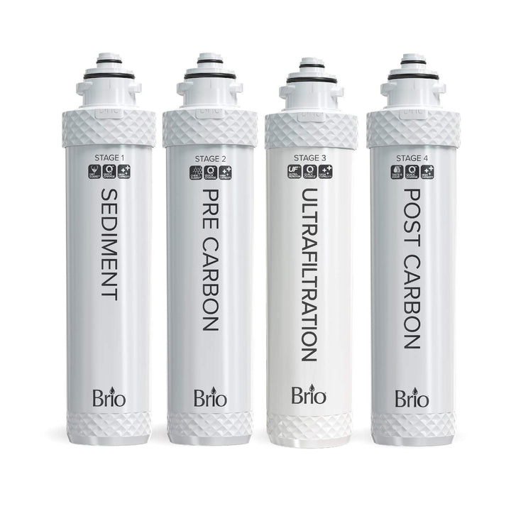 Four white Brio water filter cartridges labeled: Sediment, Pre Carbon, Ultrafiltration, and Post Carbon, arranged in a row with text and symbols on each filter indicating their filtration stage.
