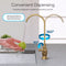 A hand washes a green apple under the Curvy Classic Series Water Faucet in brushed gold, featuring a lead-free stainless steel body with a 360° and 90° rotating spout for splash-free, convenient water dispensing at the kitchen sink.