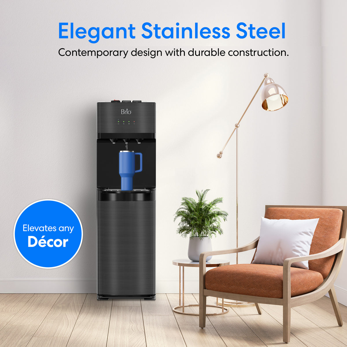 A modern living room featuring a Black Stainless Bottom Load Water Dispenser - 520, a blue mug, a tan chair with a white pillow, a potted plant on a round table, and a tall gold floor lamp set against crisp white walls and flowing curtains.