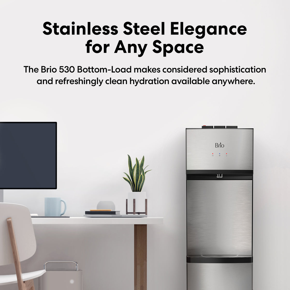 The Stainless Steel Bottom Load Water Dispenser - Model 530 BL, featuring stainless steel reservoirs and a self-cleaning function, stands beside a modern desk with a computer monitor, books, and a small potted plant. Its minimalistic design and advanced features enhance the elegant and clean atmosphere of the space.