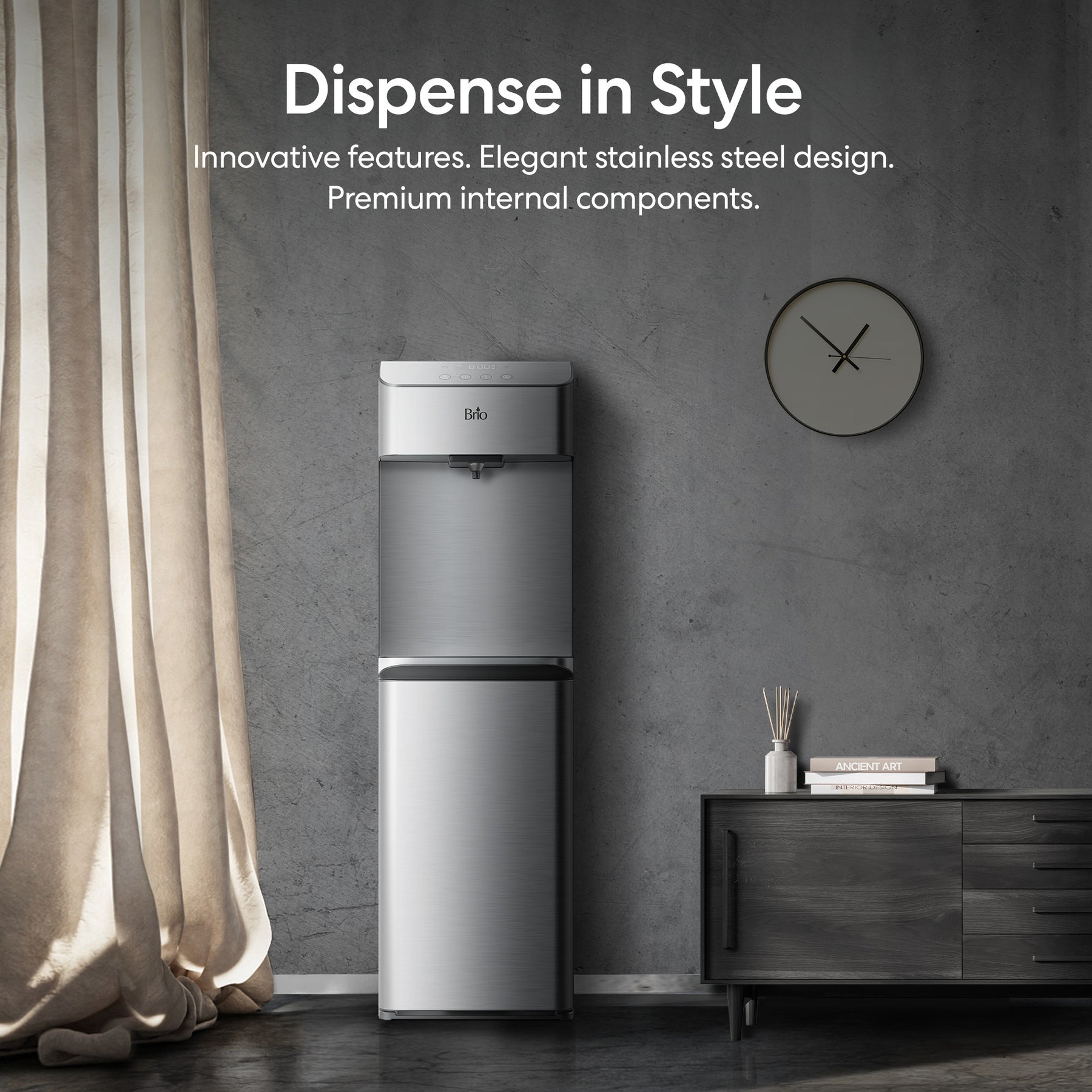 A Brio Moderna 730 Series Self-Cleaning Bottom Load Water Cooler stands by a dark wood cabinet and wall clock in a modern, softly lit room. Text above reads: Dispense in Style. Fast dispensing and premium design with innovative, self-cleaning features.