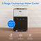 A Bottleless Countertop Water Dispenser - Model 520 sits on a wooden surface. Text highlights its compact, bottleless design with stainless steel reservoirs, tri-temperature dispensing, UV self-cleaning feature, and direct connection to the water supply—delivering an advanced hot and cold water cooler experience for any space.