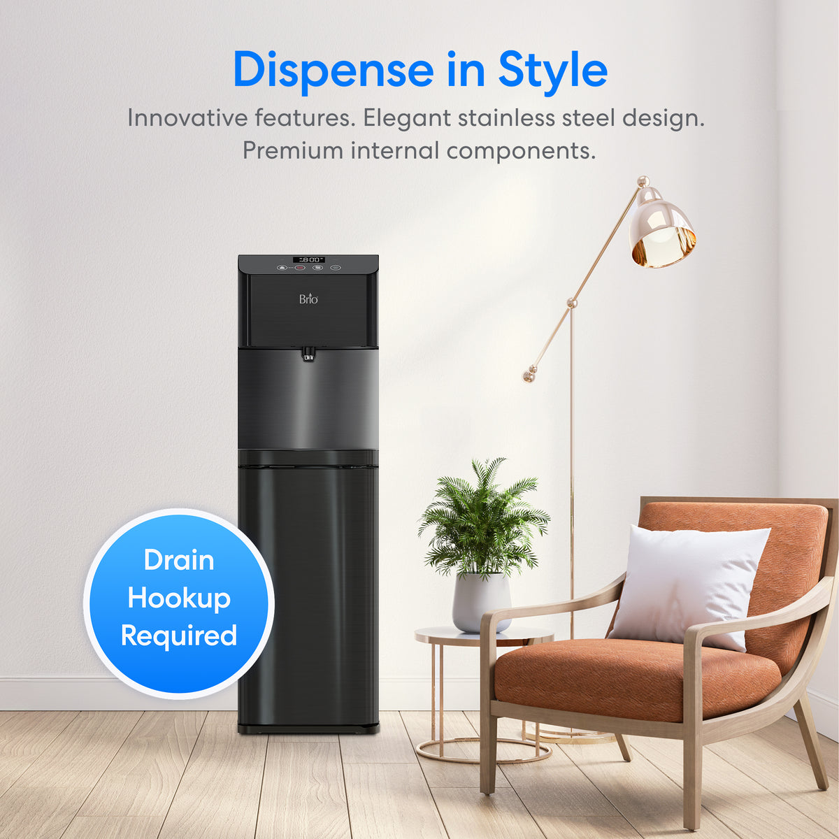 A Reverse Osmosis Black Stainless Bottleless Water Cooler - Moderna 720 sits in a modern living room alongside a brown chair, white pillow, green plant, and floor lamp. Text: Dispense in Style. Requires reverse osmosis water filtration and drain hookup.