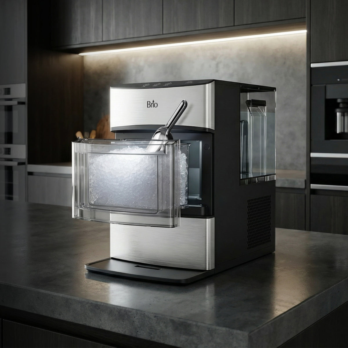A Countertop Nugget Ice Maker - 740i in stainless steel and black, featuring a clear bin filled with nugget ice, sits in a modern kitchen with dark cabinets and gray countertops.