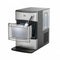 A silver Countertop Nugget Ice Maker - 740i sits on the countertop, featuring an open drawer filled with ice and a scoop resting inside. The machine boasts a modern design, a clear water reservoir on the side, and efficiently produces plenty of ice for your needs.