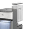 A close-up of a stainless steel Countertop Nugget Ice Maker - 740i with an open, clear plastic water reservoir on top, showcasing the spacious ice compartment and blue LED light inside.