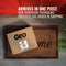 A cardboard box labeled GEO Porcelain Ceramic Crock Water Dispenser w/ Stand - Blue sits on a brown doormat in front of a red door. White text above reads: Arrives in one pieceāour packaging protects your BPA-free porcelain crock.