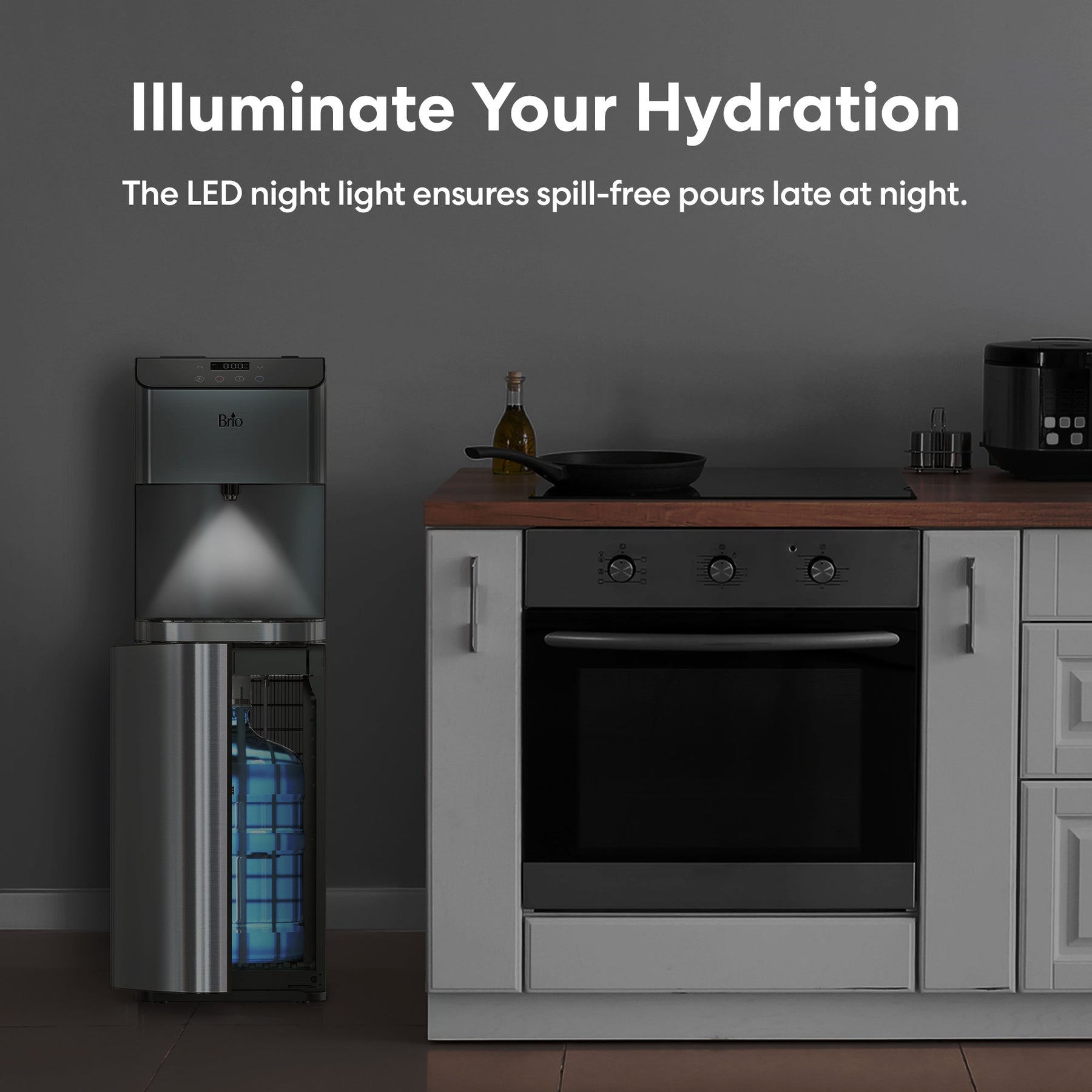 A kitchen with a refrigerator and the Brio Moderna Self-Cleaning Bottom Load Water Cooler in stylish stainless steel.