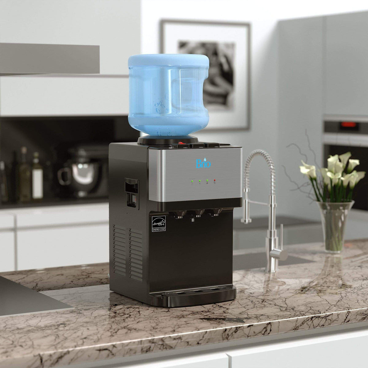 A Countertop Top Load Water Cooler - 520 Series with a blue refillable bottle sits elegantly on a marble kitchen island. Modern kitchen appliances and white cabinets in the background accentuate the cooler’s sleek black design and tri-temperature controls, offering customized refreshment.
