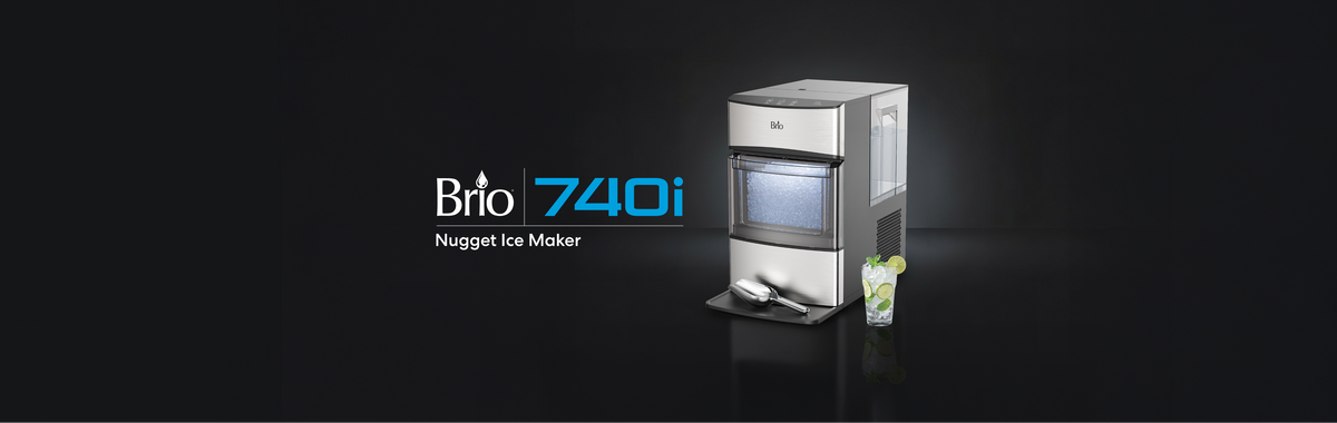 Brio 740i Nugget Ice Maker with scoop and a glass of iced lime water on a dark background