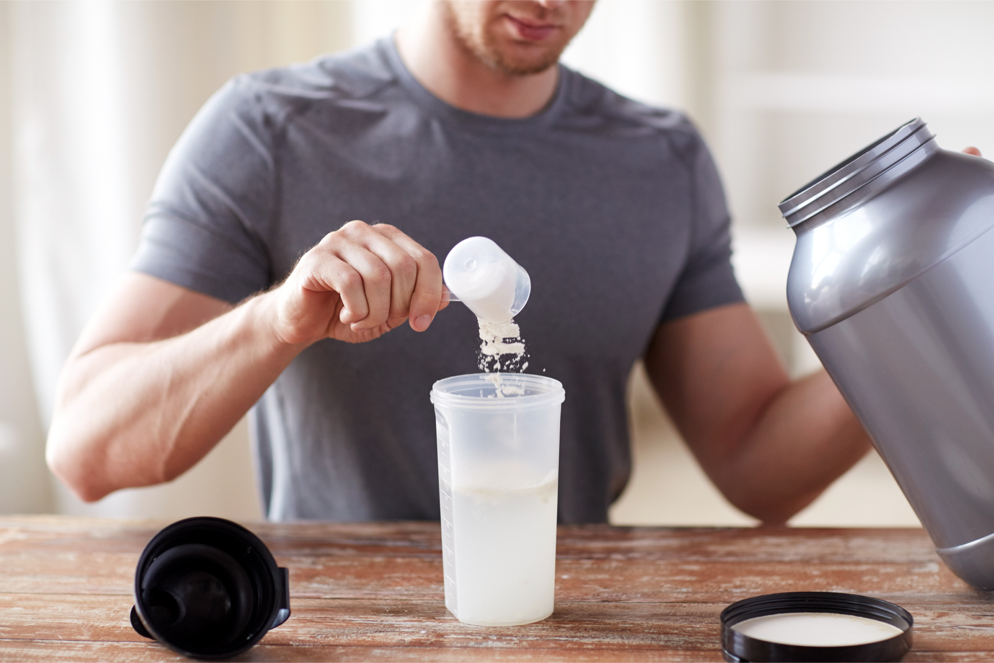 A man filling up a bottle with creatine and water