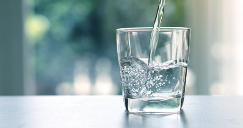 A glass of water being filled