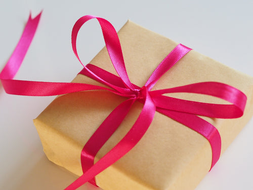 Gift wrapped in brown paper and a pink ribbon