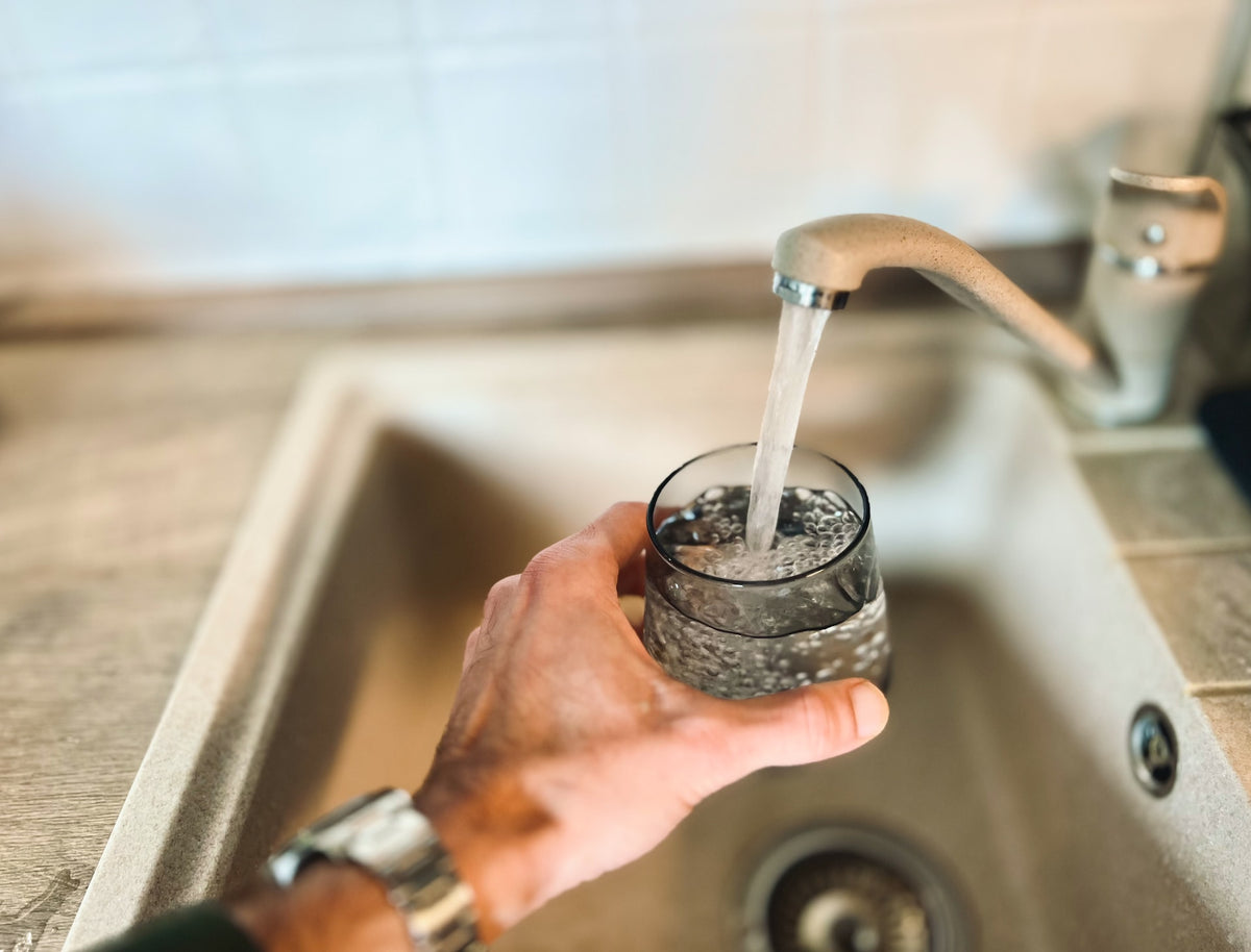 man filling a glass with tap water
