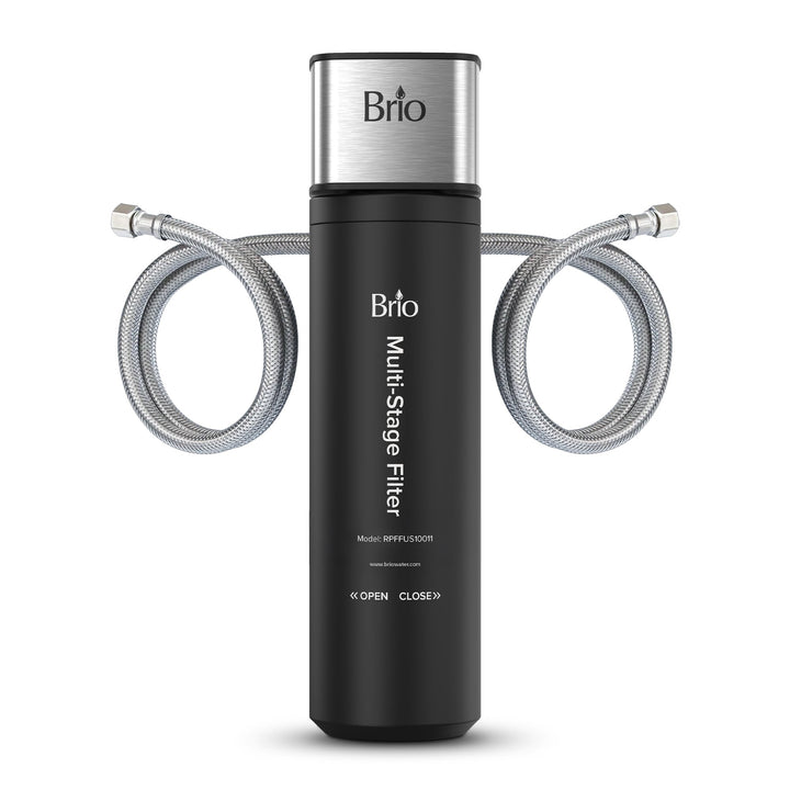 The Brio 11" Multi Stage Undersink Water Filtration System features a black cylindrical body, silver top, and two flexible metal hoses. The product name and installation instructions are printed on the front for easy reference.