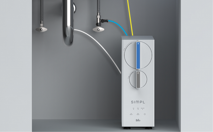 Brio SIMPL undersink water filtration system installed beneath a sink, featuring connected color-coded hoses and a sleek modern design.
