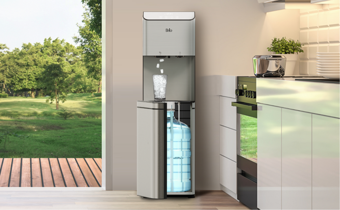 Brio bottom loading water cooler dispensing ice in a bright kitchen with a garden view.