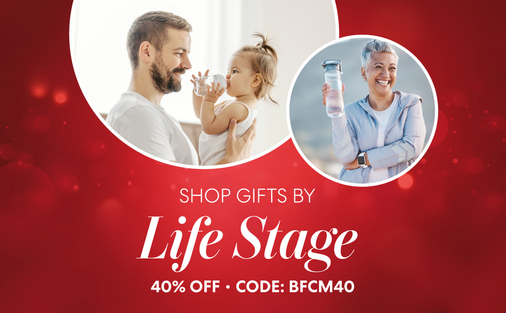 Holiday-themed Brio promotion with a red background. Text reads “Shop Gifts by Life Stage – 40% Off • Code: BFCM40.” The image shows a man holding a toddler drinking water and an older woman smiling while holding a reusable water bottle outdoors.