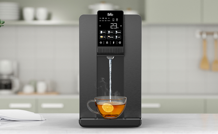 Brio Q20 Countertop Dispenser black countertop water dispenser with digital controls, dispensing hot water into a glass mug with a lemon slice in a modern kitchen.