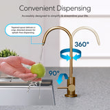 A hand rinses a green apple under the Brio Modern Series Water Faucet – Brushed Bronze; arrows highlight its 360° rotation and 90° tilt, and text showcases its splash-free, directed stream for reverse osmosis convenience.