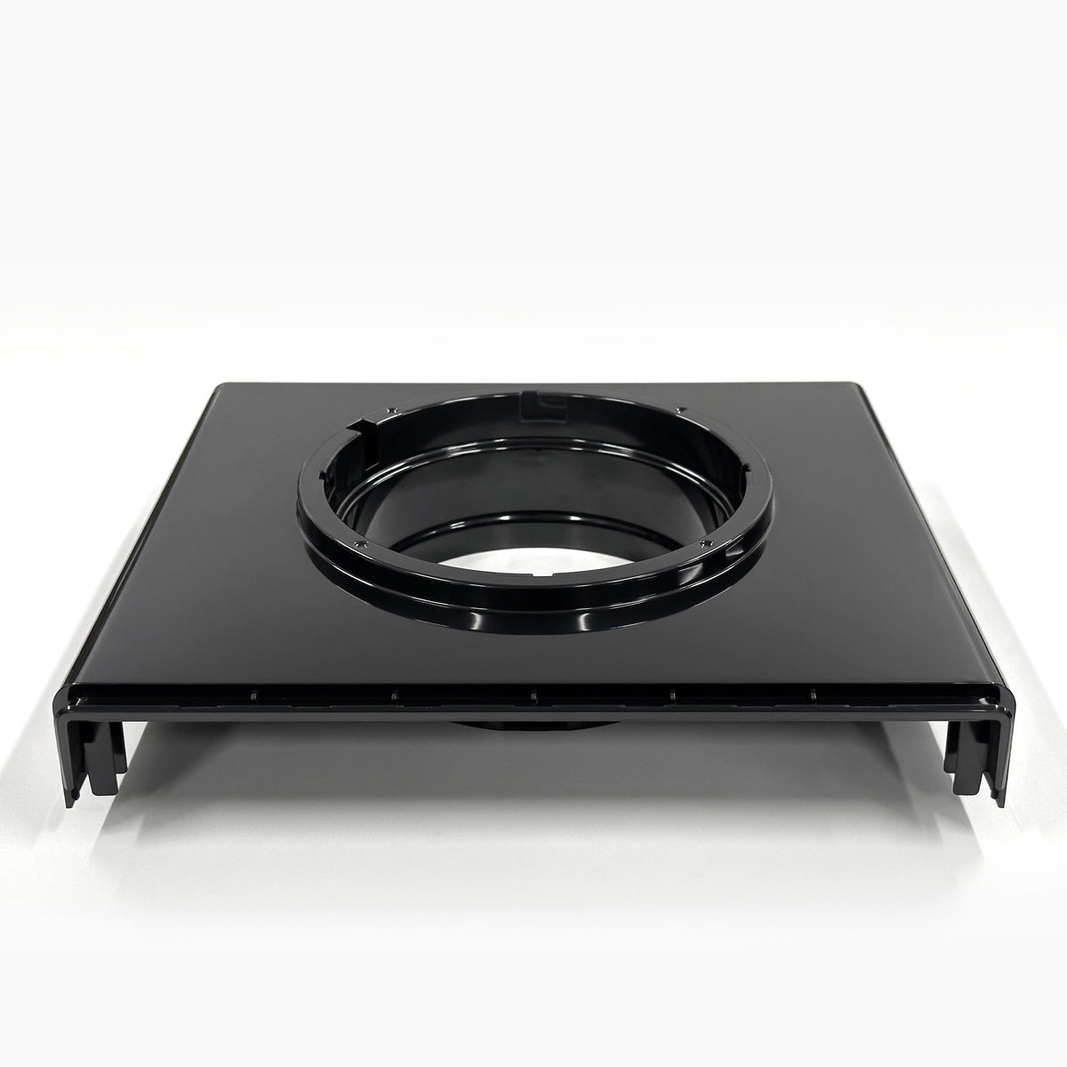 The Top Lid 520 for Top Load Coolers is a black rectangular plastic component with a large central circular opening. Seen from the front, it features raised edges and a glossy finish that gives it a sleek look.