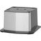 The Cooler Base for Water Dispenser - 745 Series is a square, metallic base with a brushed stainless steel finish and black accents, featuring top grooves and markings for functional design and added versatility.