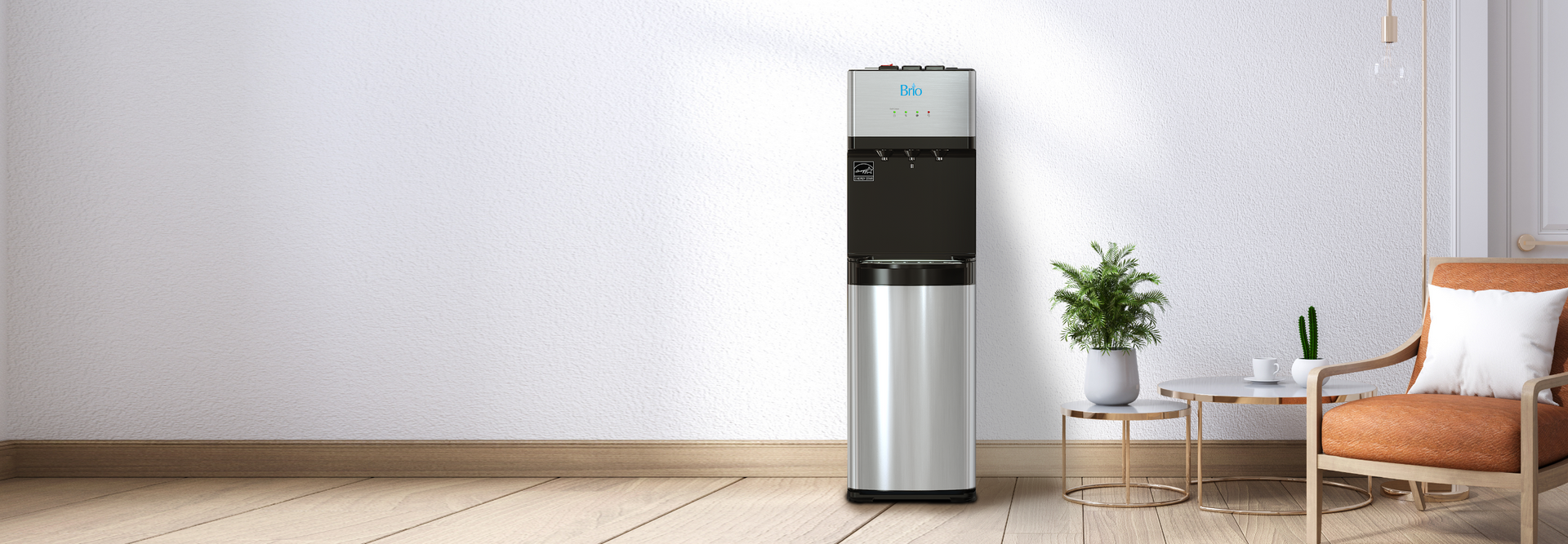 A modern water dispenser stands against a white wall next to a small table with a potted plant and an orange armchair in a bright, minimalist room.