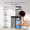 A woman effortlessly slides a 5-gallon water bottle into the lower compartment of the Bottom Load Tri-Temp Water Dispenser - Model 745. The text highlights easy bottle replacement with convenient front slide-in access, a hidden bottle design for a clean look, and no plumbing required.