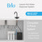 The 3-Stage Instant Hot Water Under Sink Dispenser System - Matte Black features a sleek black dual flow faucet, two white filter cartridges, a black boiler tank, and clearly labeled system features. This efficient under sink dispenser delivers up to 55 cups of hot water per hour.