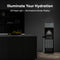 A Stainless Steel Ultrafiltration Bottleless Water Dispenser - Model 520 with an open filter compartment stands in a dark kitchen. White text above reads, “Illuminate Your Hydration,” highlighting features like advanced ultrafiltration, an LED night light, and an illuminated indicator display.