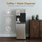 A 4-Stage Reverse Osmosis Coffee Maker & Bottleless Water Cooler Dispenser - Moderna 730 sits beside a wooden cabinet with two small potted plants. This stainless steel unit features a single-cup coffee maker, UV self-cleaning technology, direct plumbing connection, and advanced reverse osmosis filtration for crisp, pure hydration.