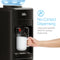 A hand holds a white mug under a Black Top Load Water Cooler - 320 Slim Series with large push-paddles. Text reads: No-Contact Dispensing. Large push-paddles allow for sanitary dispensing.