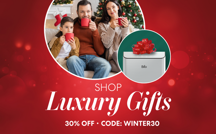 Shop luxury gifts—Brio holiday deal, 30% off with code WINTER30, family by Christmas tree and Brio gift with bow.