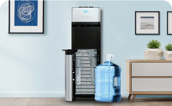 A water cooler with its door open and a large blue water jug beside it sits against a light blue wall, near a modern dresser and framed artwork.