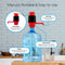 A Manual Water Bottle Pump - Red & Black is attached to a large BPA-free 3- or 5-gallon bottle, showing its pump head, dust cap, tubing, and universal fit. The water dispenser sits on a kitchen counter next to a glass of water.