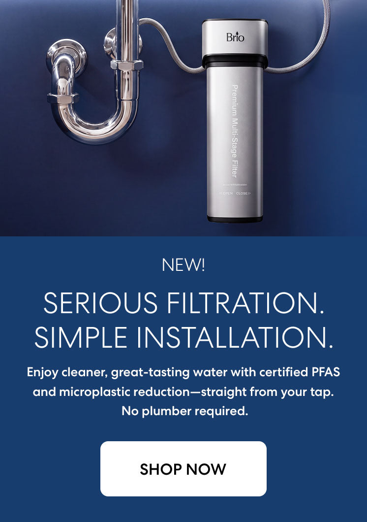 Brio premium undersink filtration system with PFAS removal shown installed to a sink on a dark blue background.