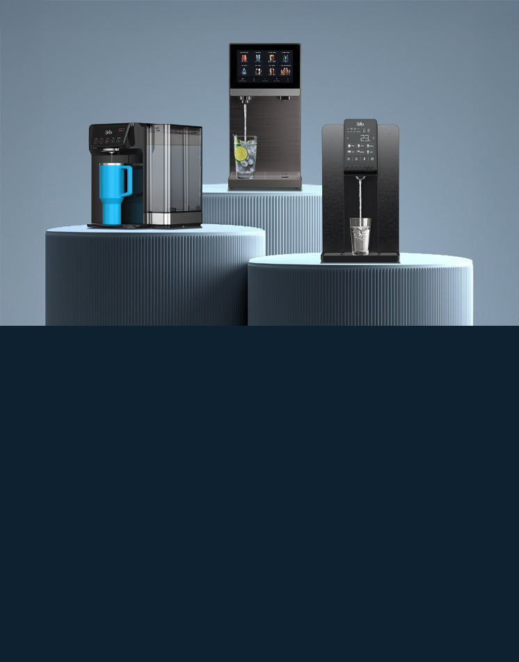 Three Brio Hydroport countertop water dispensers displayed on ribbed blue-gray pedestals. From left to right: the black Hydroport 630 with a clear side water tank fills a blue tumbler, the dark stainless Hydroport Q60 with a large touchscreen menu pours water into a glass with ice and a lime slice, and the black Hydroport Q20 with a digital touch panel fills a clear glass.